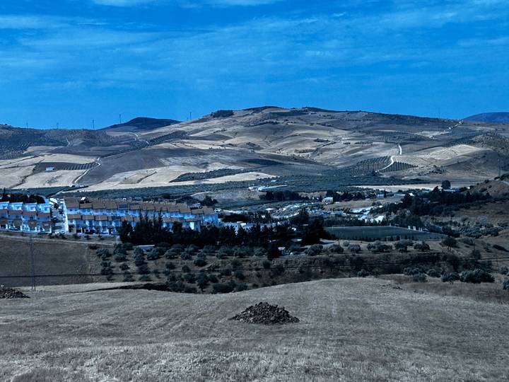 Paysage avec des collines ondulantes et une vue lointaine d'un petit village.