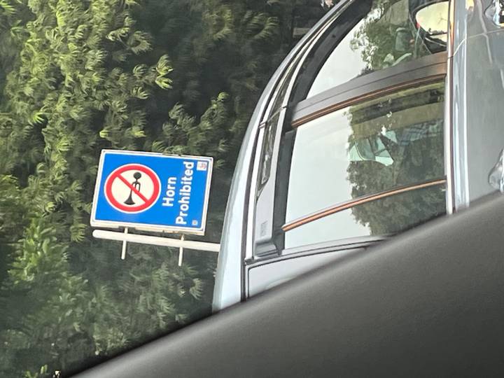 Ein Verkehrsschild mit "Hupen verboten" auf einer Straße.