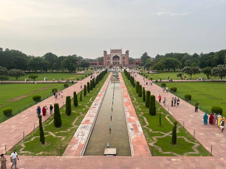 Der Eingang und Garten des Taj Mahal mit Besuchern.