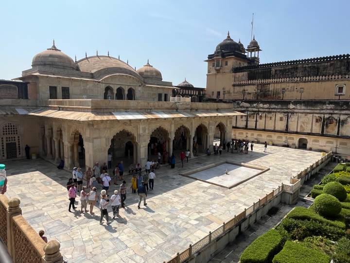 Große Gruppe von Menschen, die eine antike Festung mit beeindruckender Steinarchitektur besichtigt.