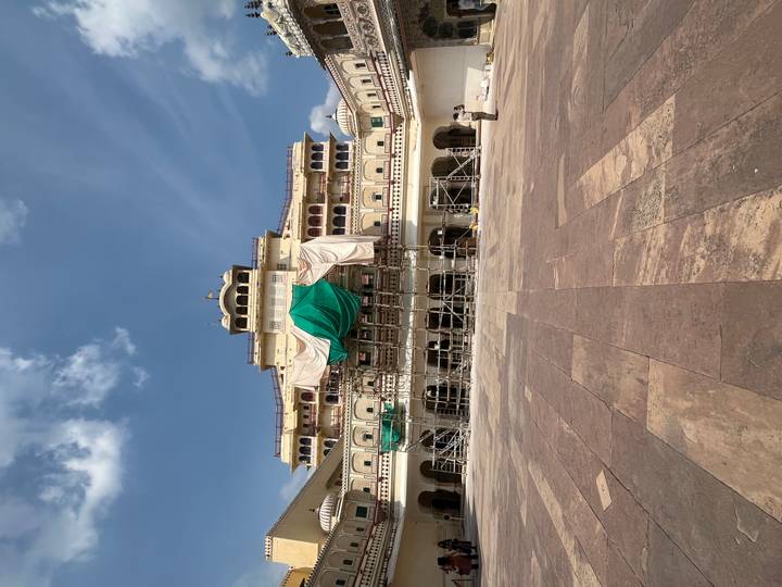 Palastgebäude unter Renovierung mit Gerüst und Planen in einem Innenhof.