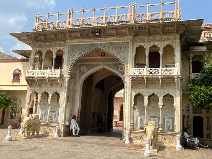 Verziertes Eingangstor zu einem historischen Gebäude mit kunstvollen Schnitzereien und Elefantenstatuen.