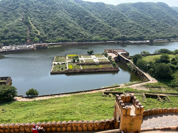 Inselgarten in einem Fluss vor einer Hügelkulisse.