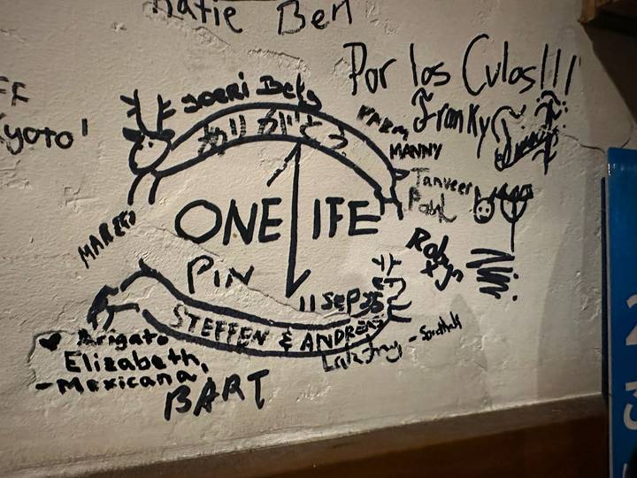 Mur de graffitis avec divers dessins et textes.