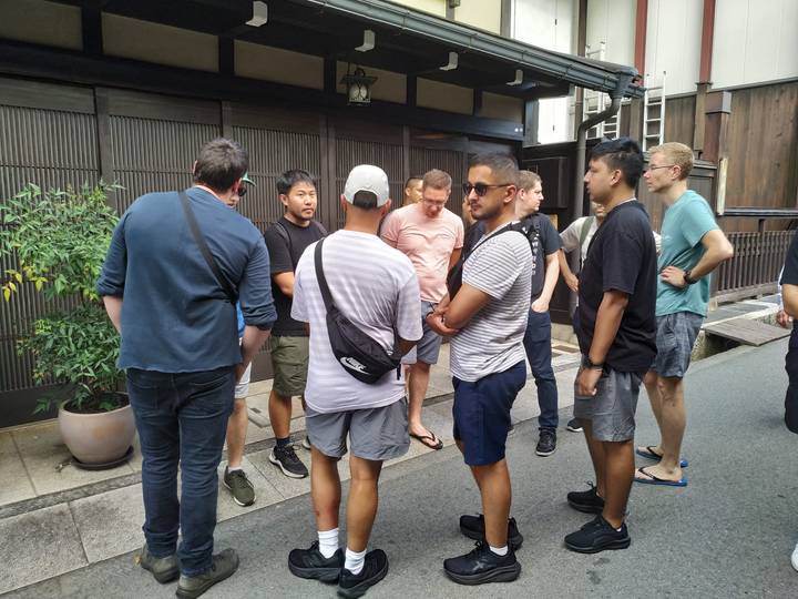 Groupe de personnes parlant dans une rue dans un cadre japonais traditionnel.