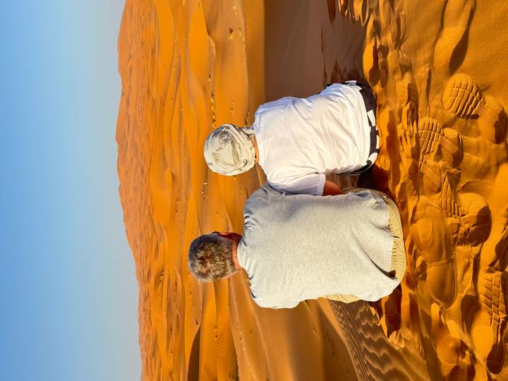 Deux personnes assises profitant de la vue sur les dunes du désert.