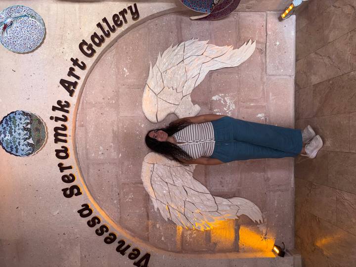 Personne debout avec art mural d'ailes d'ange.