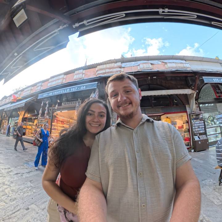Couple souriant dans un marché animé.