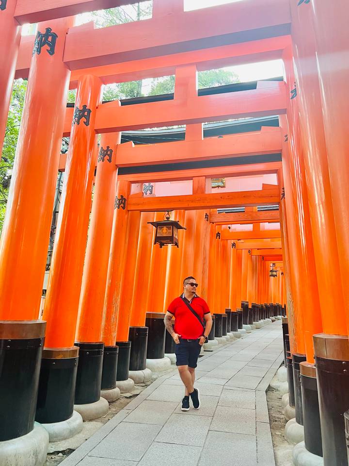 A subject walking through the Fushimi Inari Shrine's torii gates.