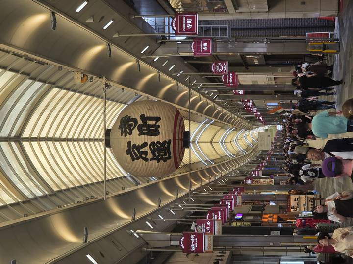Rue commerçante animée avec des lanternes à Kyoto.
