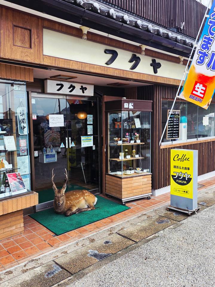 Devanture de magasin nommée Fukaya avec une statue de cerf devant.
