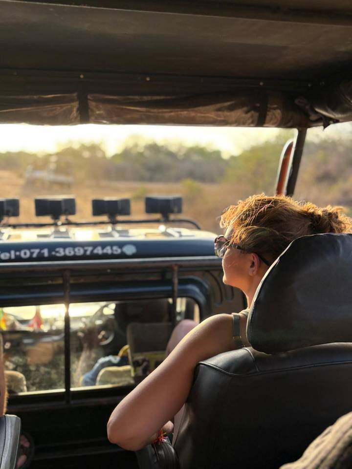 Personne assise dans une jeep regardant un paysage aride.