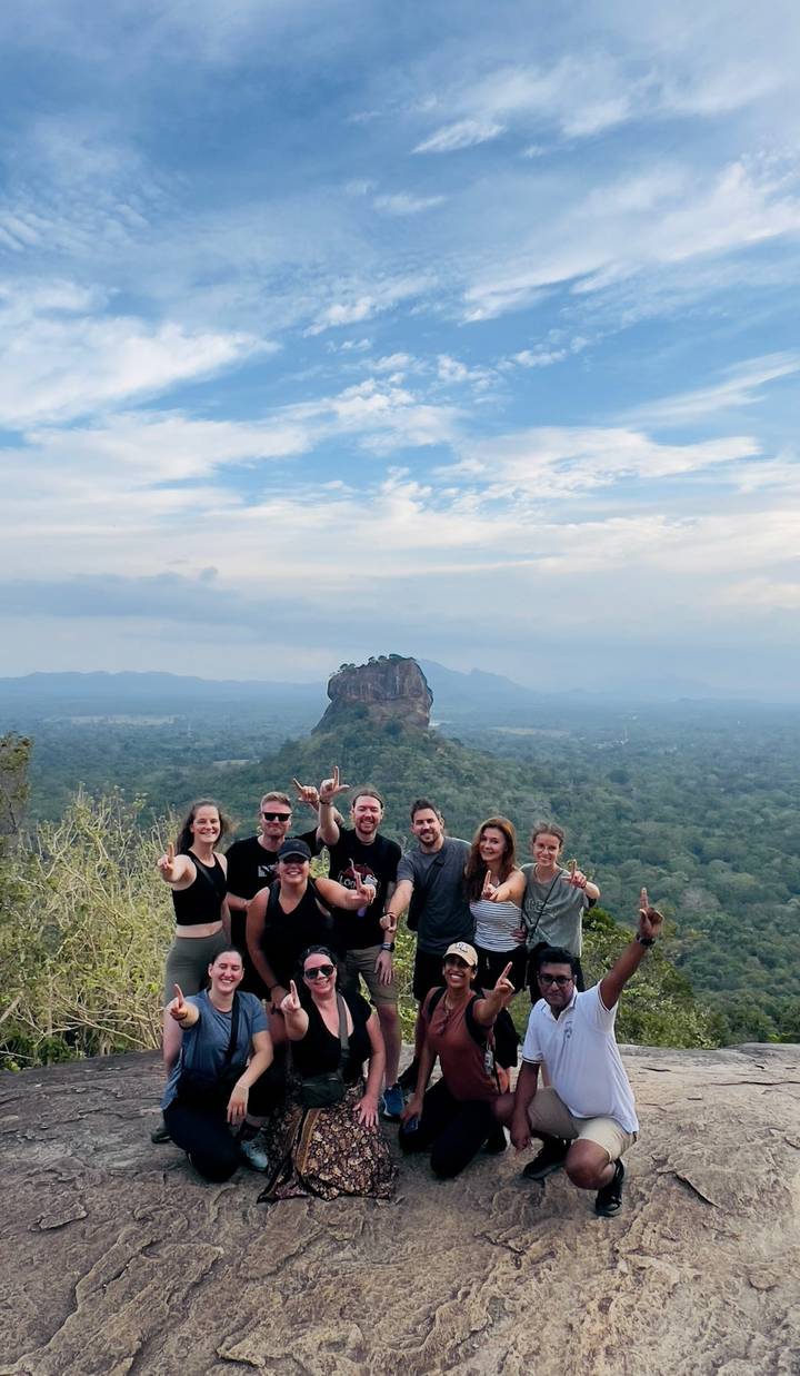 Groupe de personnes avec une formation rocheuse en arrière-plan.