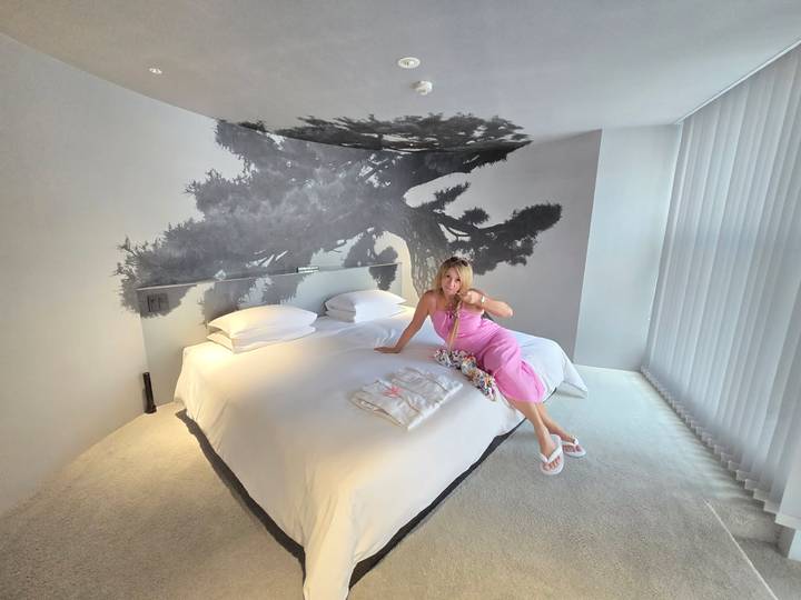 Personne assise sur un lit dans une chambre d'hôtel moderne.