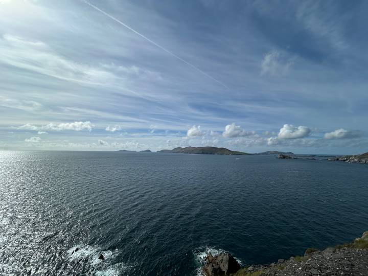 Vue sur mer ouverte avec îles lointaines et légère couverture nuageuse.