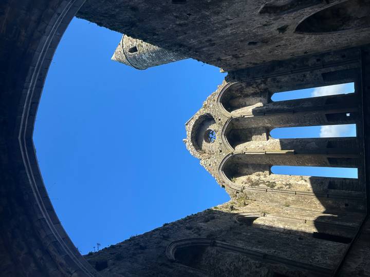 Structure de pierre ancienne avec une entrée voûtée et un ciel bleu.