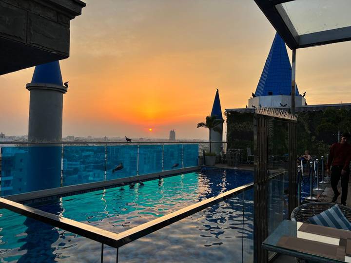 Piscine sur le toit avec vue sur le coucher de soleil et horizon urbain.
