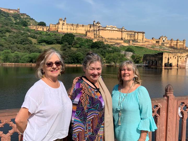 Trois femmes posant avec le Fort d'Amber en arrière-plan.