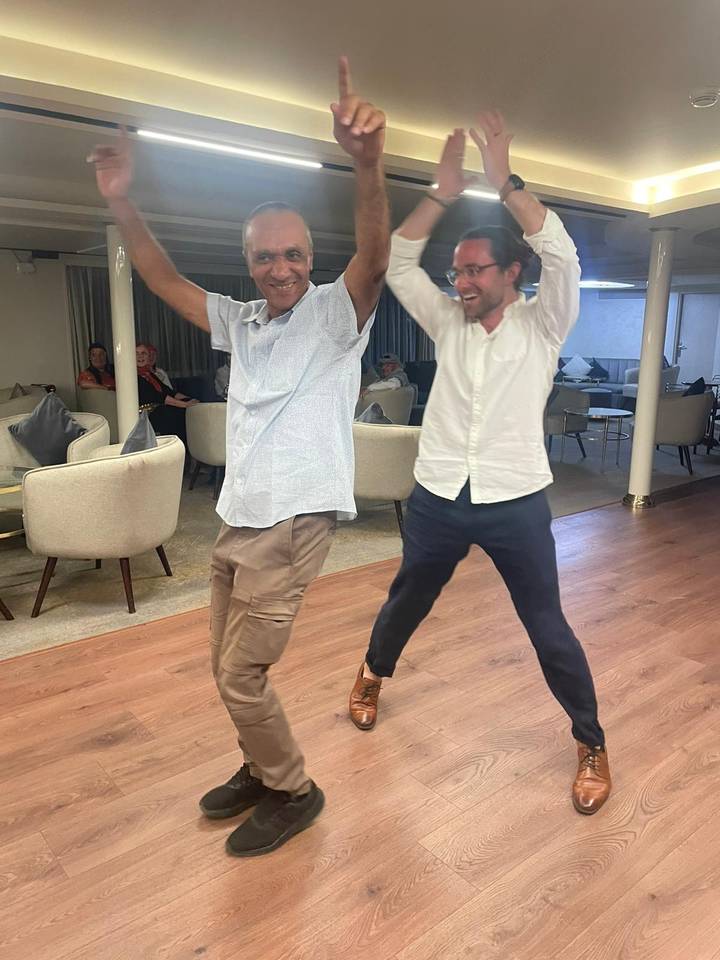 Deux personnes dansant joyeusement à l'intérieur.