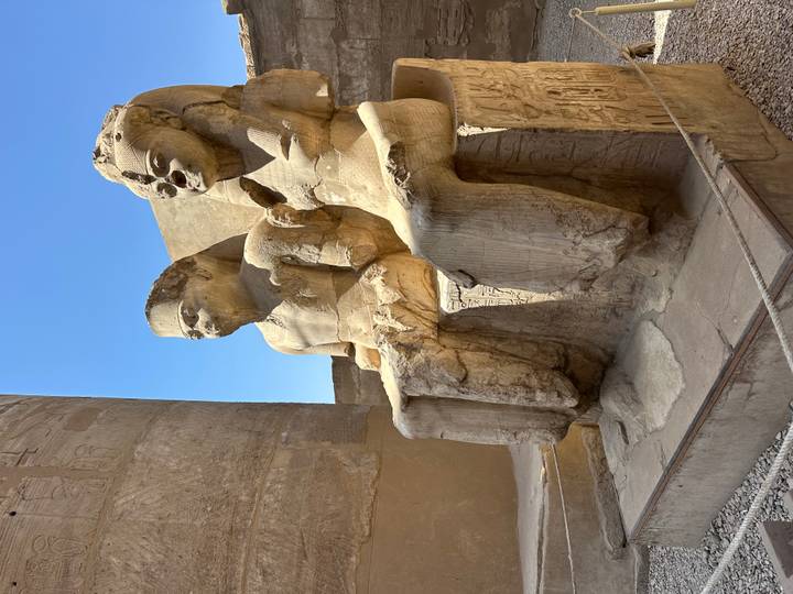 Deux statues anciennes assises côte à côte.