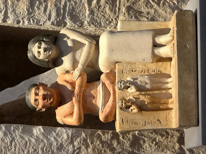 Statue ancienne d'un couple assis.