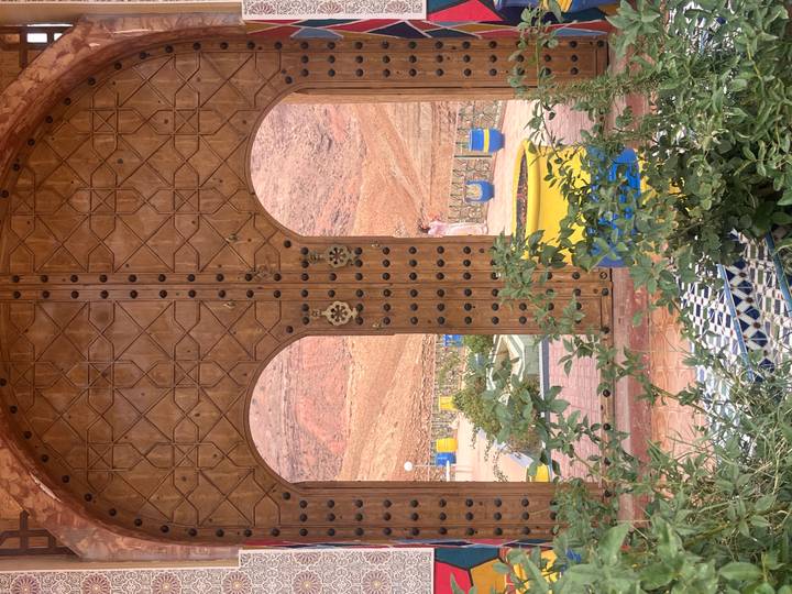 Decorative wooden doorway with a view of desert landscape.