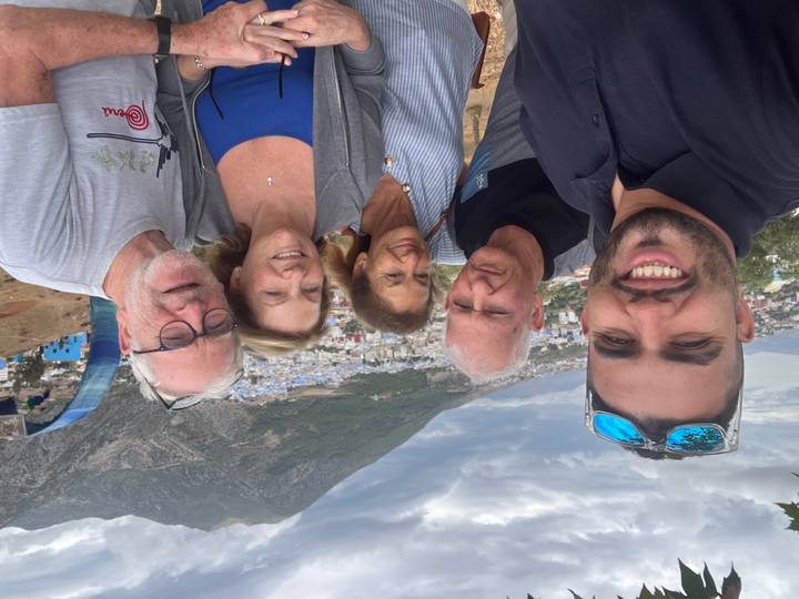 Group photo with people posing in front of a mountainous backdrop.