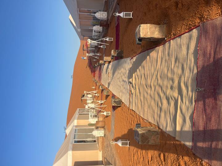 Luxury tent accommodation in the desert with a red carpet.