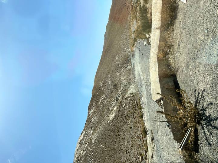 Paysage rocheux avec collines arides sous un ciel bleu dégagé.