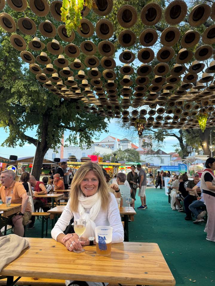 Repas en plein air avec un marché animé en arrière-plan et des gens.
