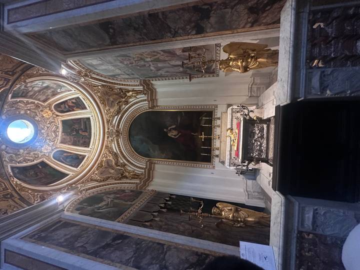 Un intérieur d'église orné avec des peintures religieuses et des accents dorés.