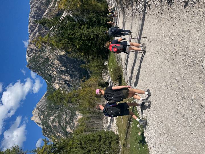 Randonneurs marchant sur un sentier avec de hautes montagnes alentour.