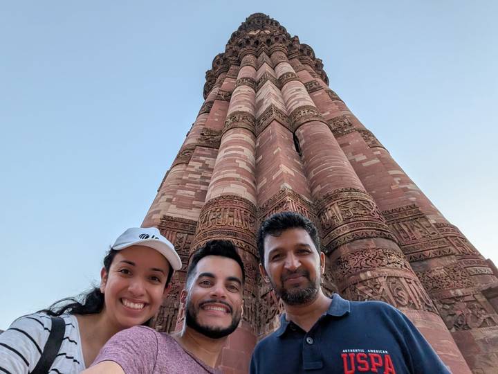 Selfie de groupe avec une haute tour historique en brique en arrière-plan.