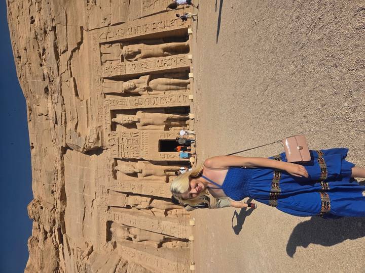 Touriste devant un temple ancien avec des statues.