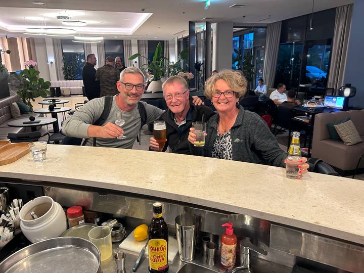 Des gens savourant des boissons dans un bar au cadre chaleureux.