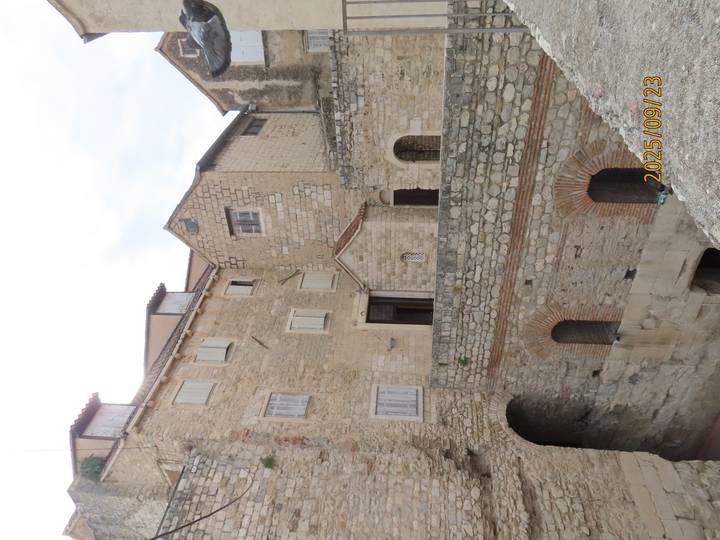 Bâtiments en pierre avec fenêtres et volets.