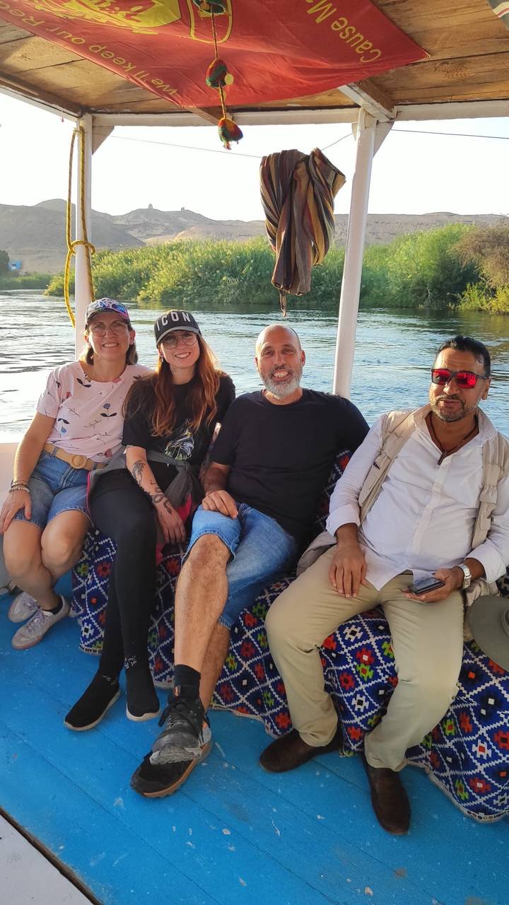 Four people sitting on a boat, smiling at the camera.