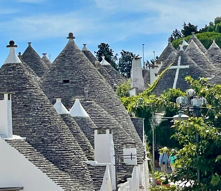 Vue rapprochée de maisons traditionnelles en pierre avec des toits coniques.
