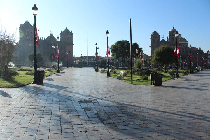 City square with a church and Peruvian flags