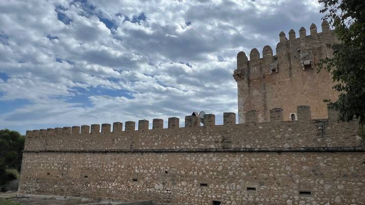 Anciens murs de forteresse sous un ciel partiellement nuageux.