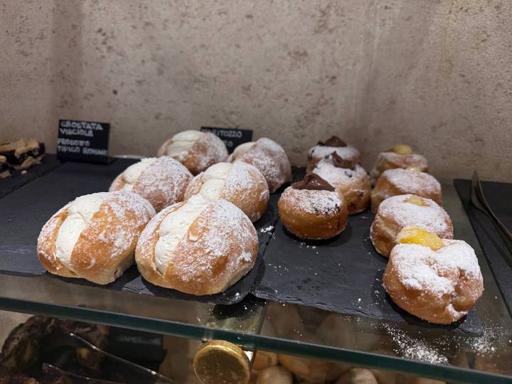 Pâtisseries italiennes exposées avec des panneaux indiquant les parfums.