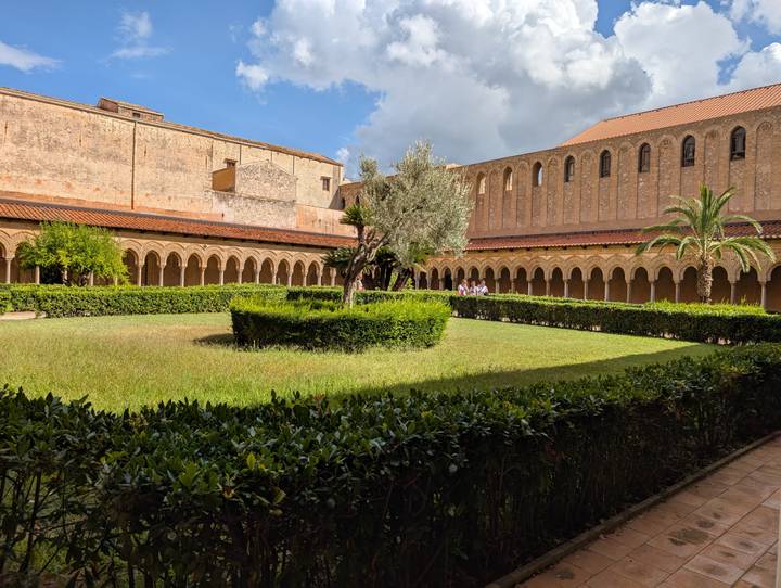 Cour d'un monastère italien avec des haies soigneusement taillées