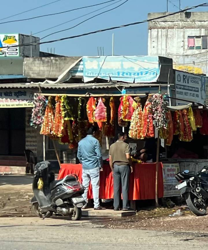 Étal de marché avec des guirlandes colorées et des gens