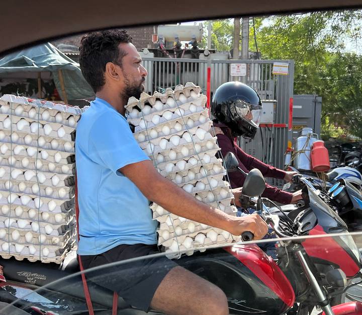 Homme transportant des boîtes d'œufs sur un vélo