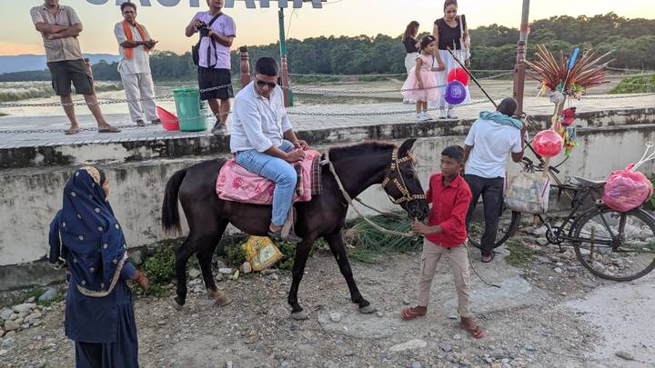 Des personnes interagissant près d'un vélo garé et d'un cheval avec un cavalier.