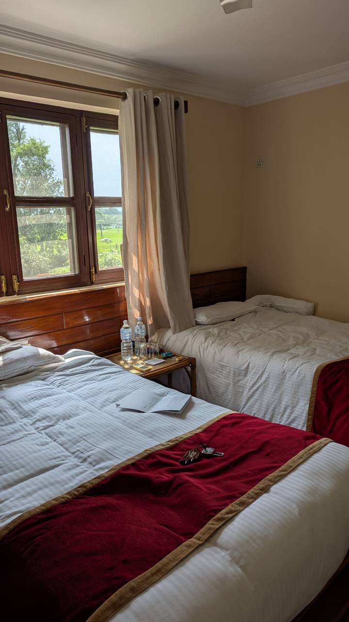 Chambre d'hôtel simple avec deux lits et une petite table.