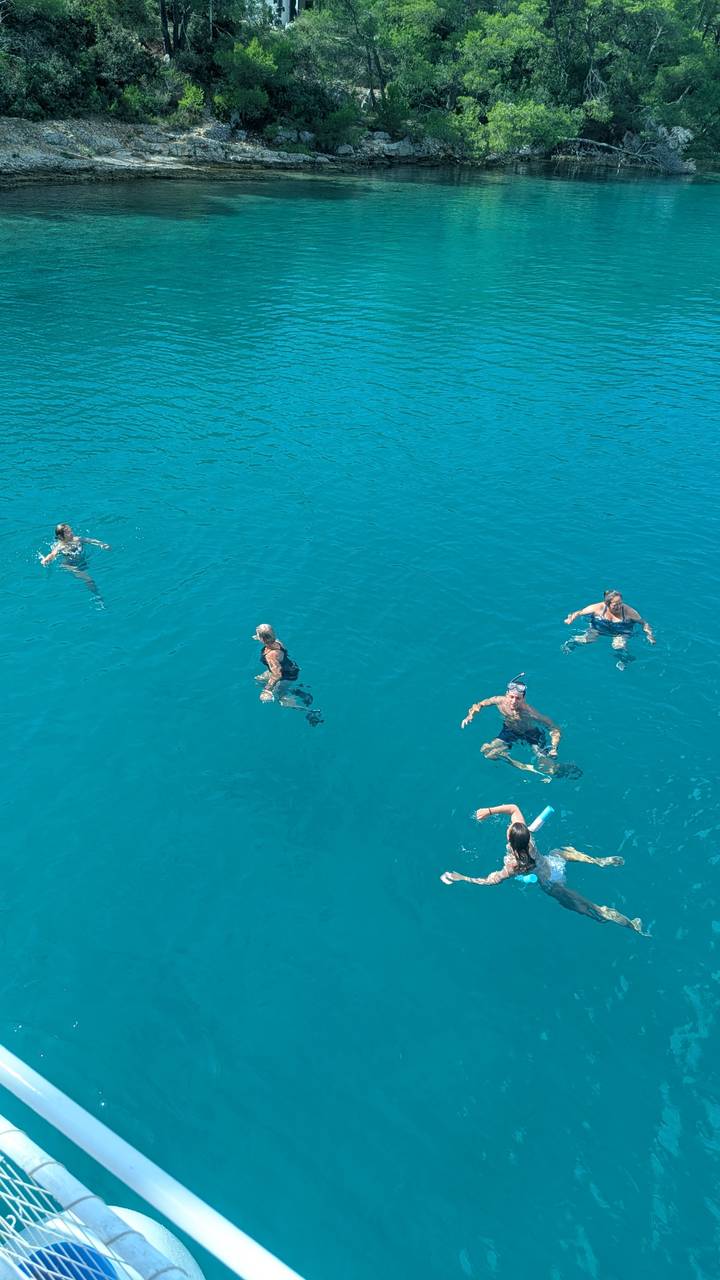 Des gens qui nagent dans une mer bleue claire.