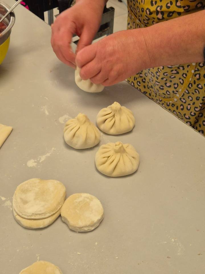 Des khinkalis étant préparés sur une surface couverte de farine.