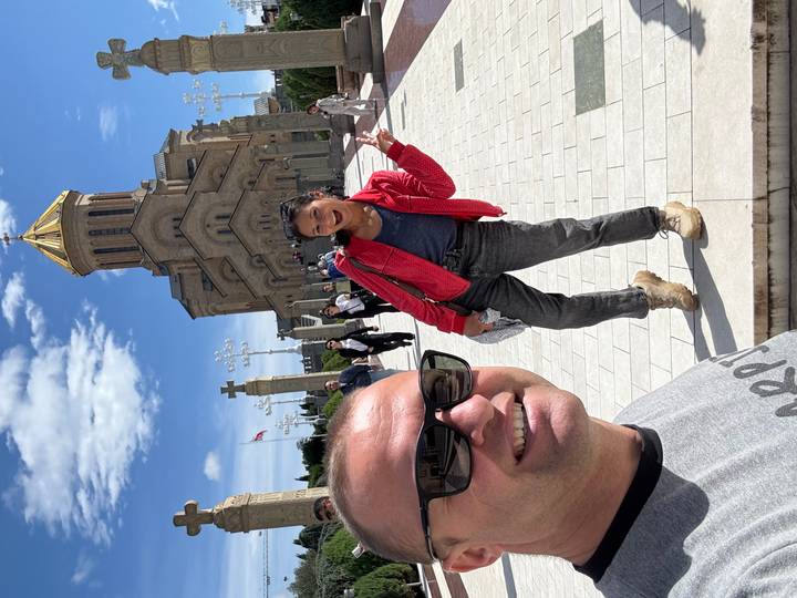 Des touristes devant une grande cathédrale avec un dôme doré.