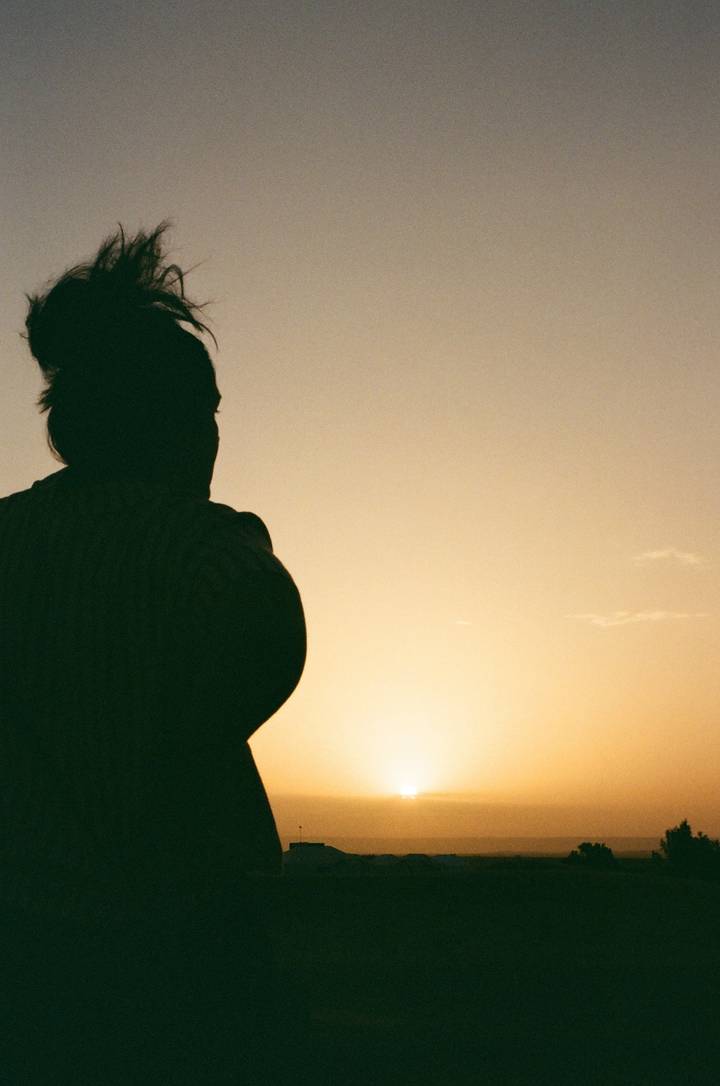 Silhouette d'une personne contre un coucher de soleil.